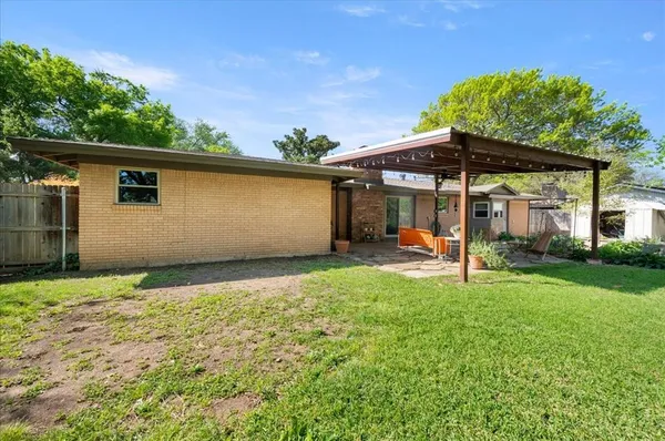 a view of a house with backyard and sitting area