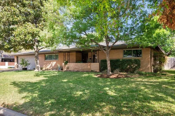 a backyard of a house with table and chairs and potted plants