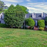 a view of a house with a yard and sitting area