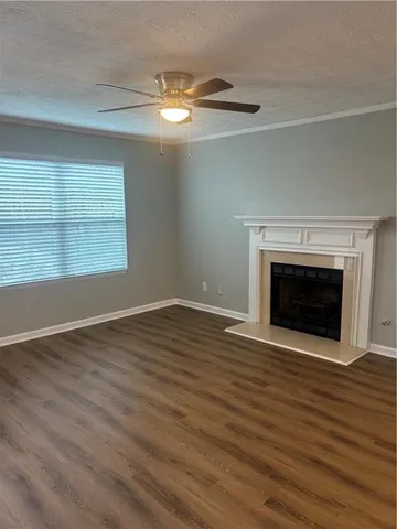 a view of empty room with wooden floor and fireplace