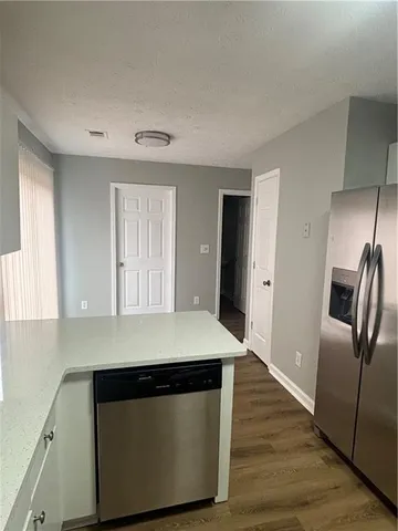a kitchen with stainless steel appliances wooden floor sink and wooden floor