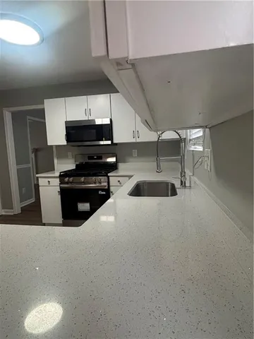 a kitchen with kitchen island a sink stove and refrigerator