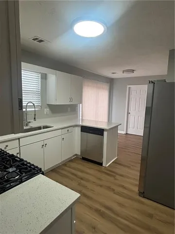 a kitchen with stainless steel appliances a white stove top oven sink and cabinets