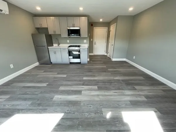 a view of kitchen with microwave stove refrigerator and cabinets
