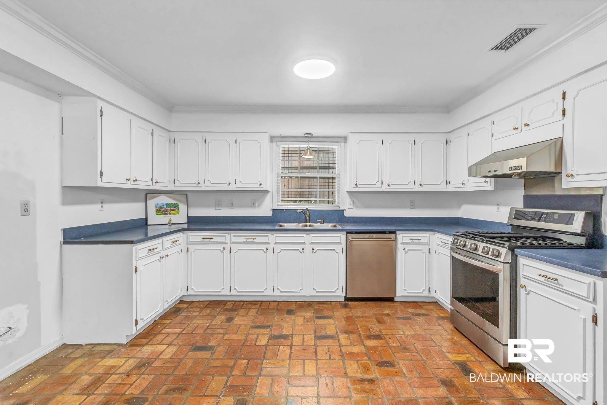 309 West Brandy Run Road Mobile, AL 36608 - Photo 19 of 100 Kitchen with stainless steel appliances, brick floors, dark countertops, white cabinetry, and ornamental molding