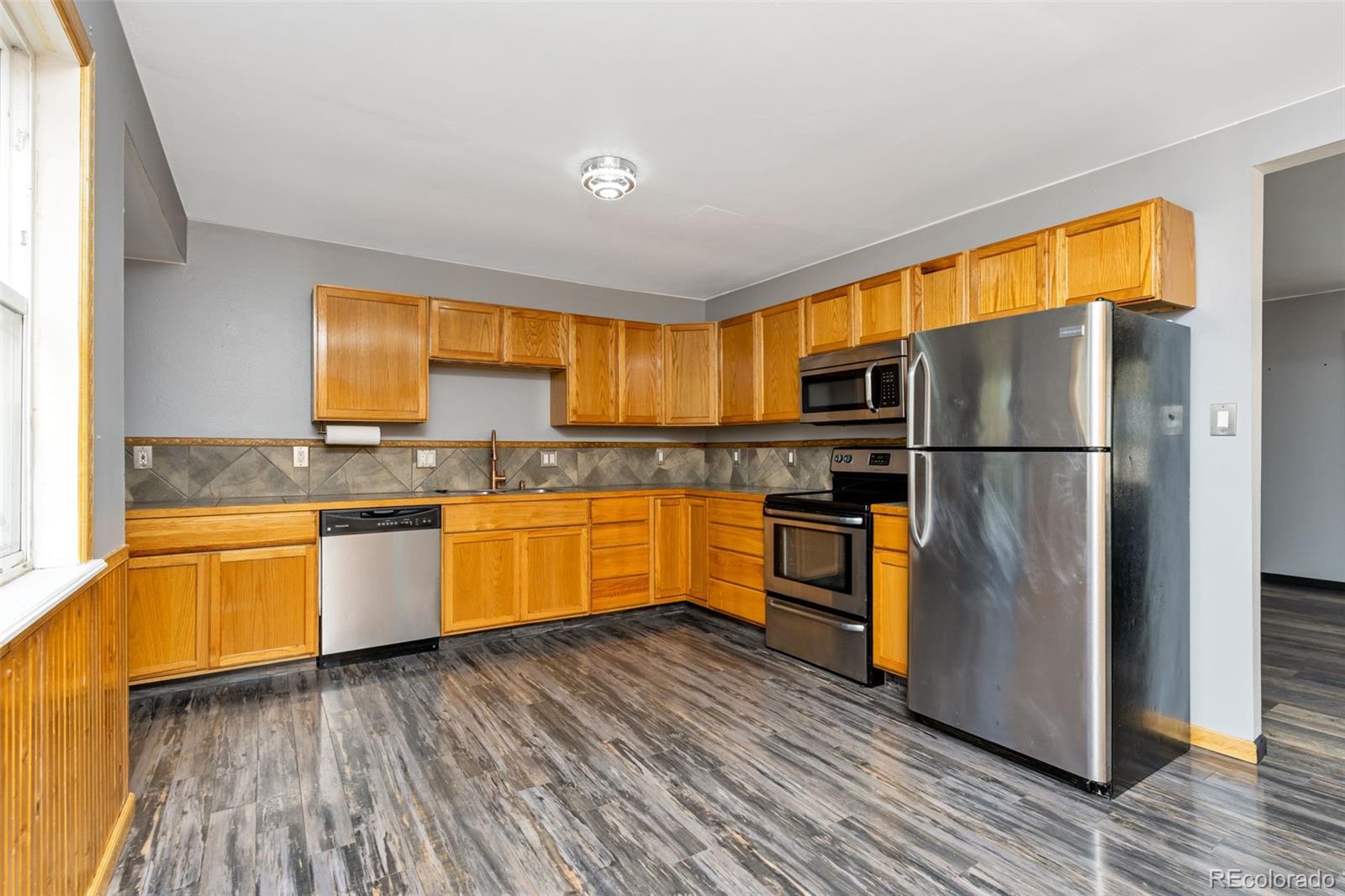 1781 Rowena Street Thornton, CO 80229 - Photo 14 of 21 a kitchen with stainless steel appliances granite countertop a refrigerator and a stove top oven