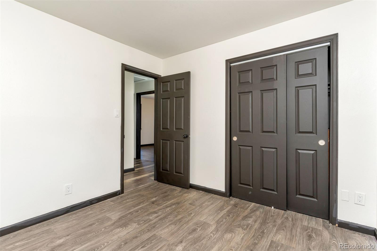 1781 Rowena Street Thornton, CO 80229 - Photo 7 of 21 an empty room with wooden floor and closet area