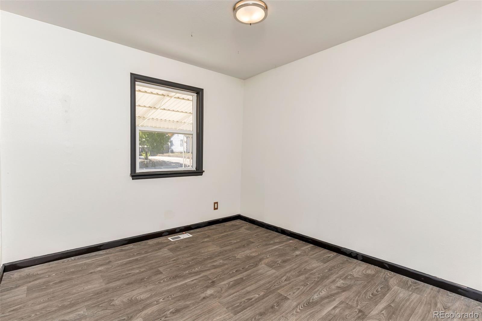 1781 Rowena Street Thornton, CO 80229 - Photo 8 of 21 a view of empty room with wooden floor and fan
