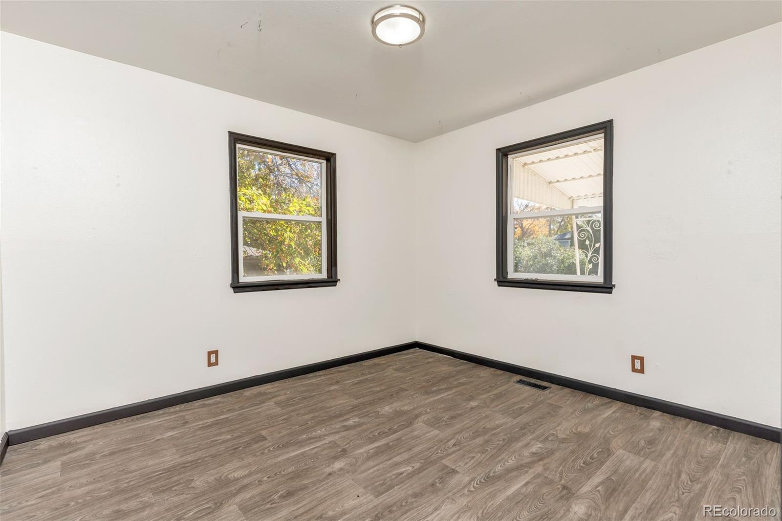1781 Rowena Street Thornton, CO 80229 - Photo 10 of 21 an empty room with wooden floor and windows