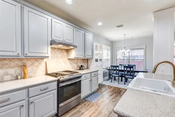 a kitchen with granite countertop a sink stainless steel appliances and cabinets