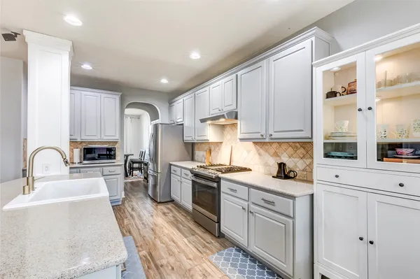 a kitchen with a sink white cabinets and stainless steel appliances