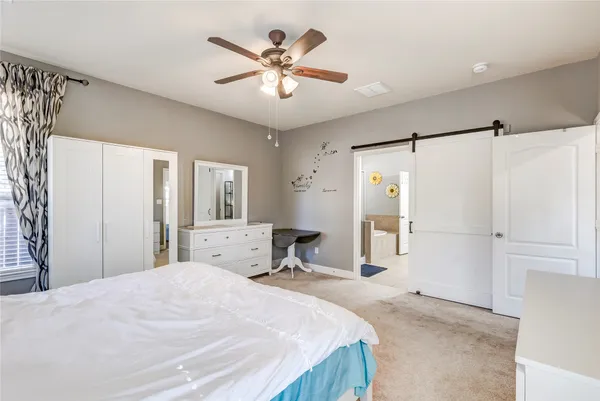 a bedroom with a large bed and a chandelier