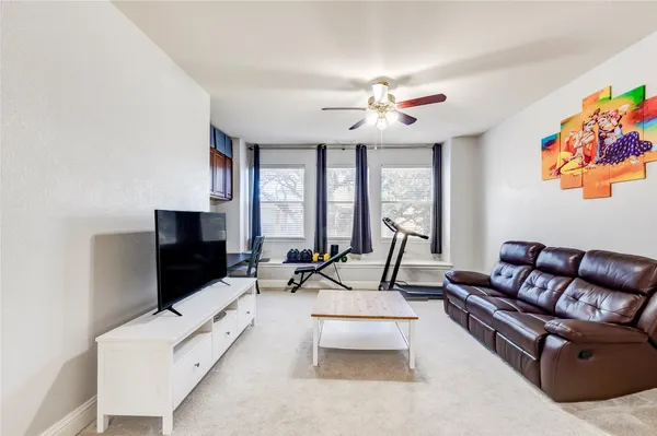 a living room with furniture a flat screen tv and a floor to ceiling window