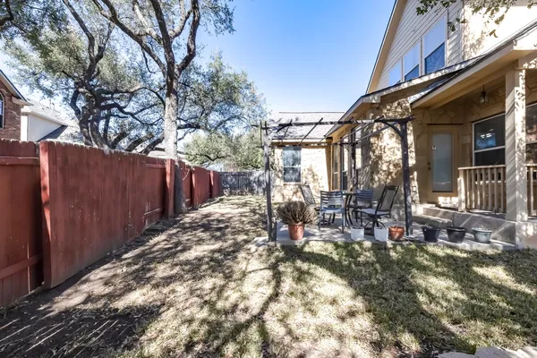 a view of a backyard with table and chairs and wooden fence