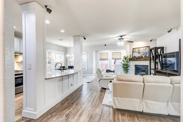 a large living room with stainless steel appliances kitchen island granite countertop furniture and a fireplace