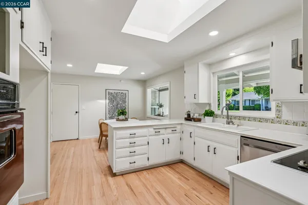 a kitchen with cabinets appliances a sink and a window