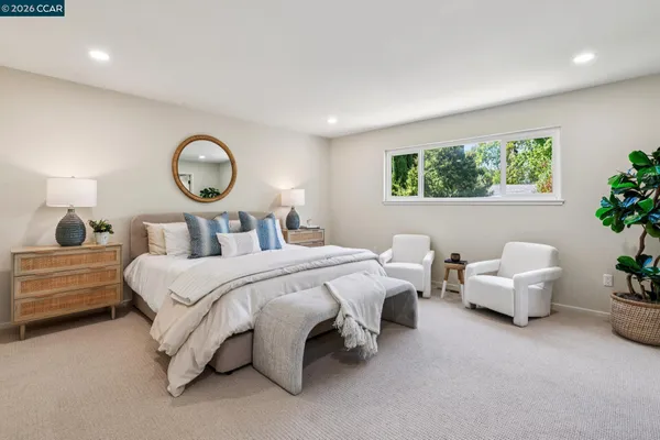 a bedroom with a large bed and a potted plant