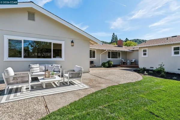 a view of a house with backyard and sitting area
