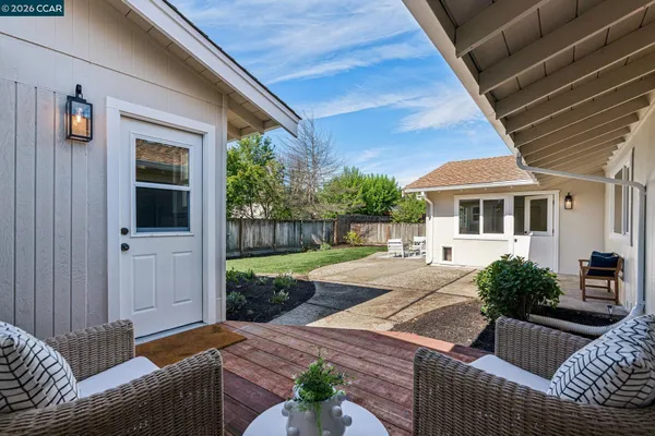 a view of a backyard with wooden fence and a bench