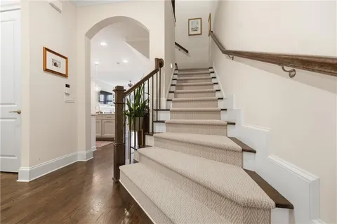 a kitchen with stainless steel appliances kitchen island granite countertop a refrigerator a sink dishwasher a oven with white cabinets and wooden floor