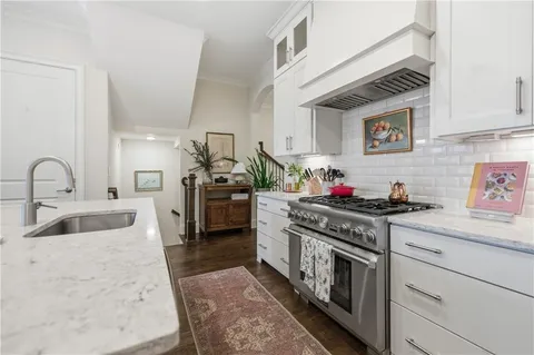 a kitchen with stainless steel appliances a dining table chairs stove microwave and cabinets