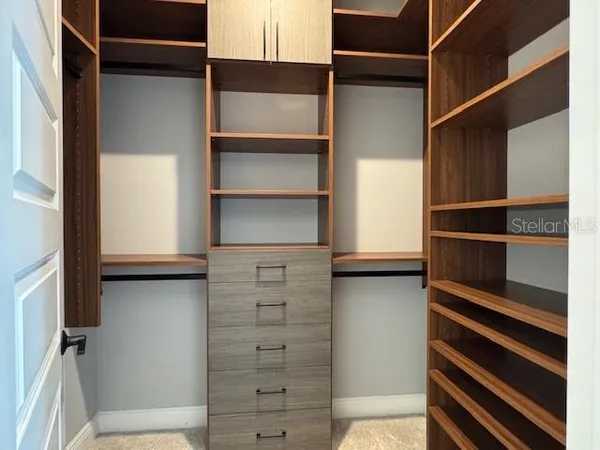 a view of walk in closet with empty racks