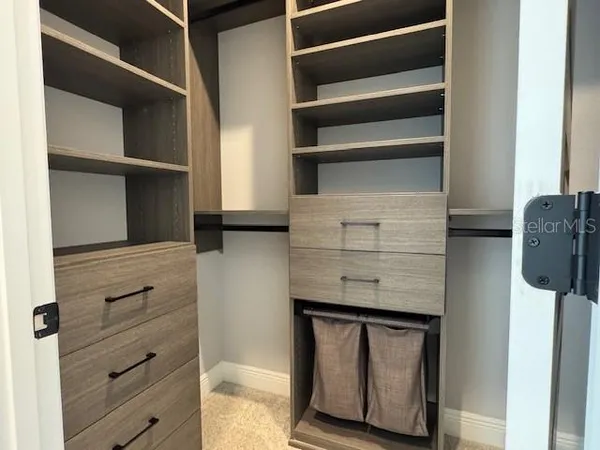 a view of walk in closet with clothes and shoes