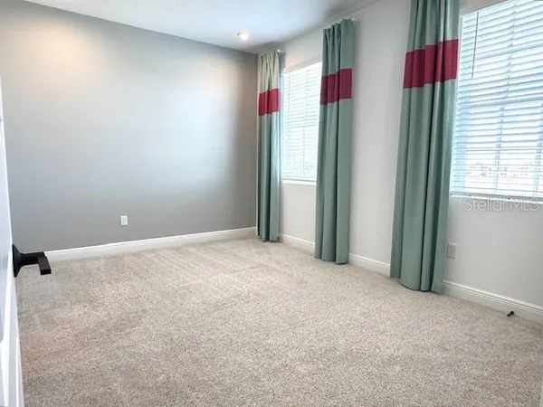 an empty room with windows and closet