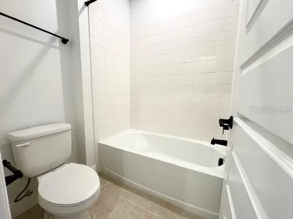 a white toilet sitting next to a bath tub