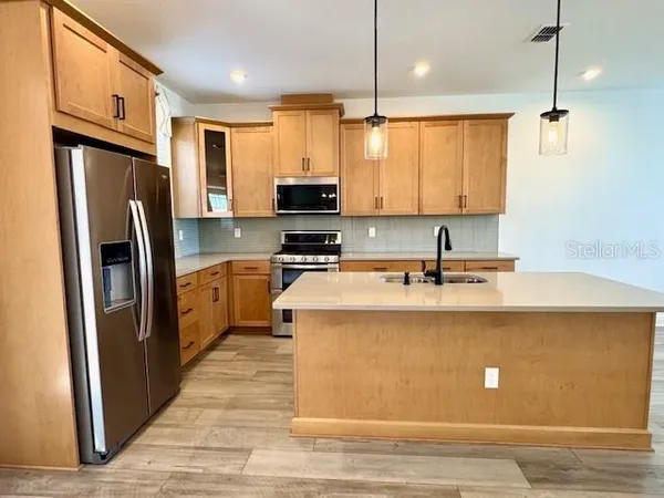 a kitchen with stainless steel appliances a refrigerator sink and cabinets