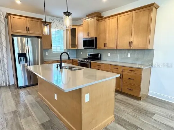 a kitchen with stainless steel appliances granite countertop a sink a stove and refrigerator