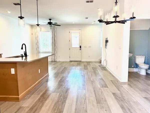a view of a kitchen with a sink wooden floor and a living room