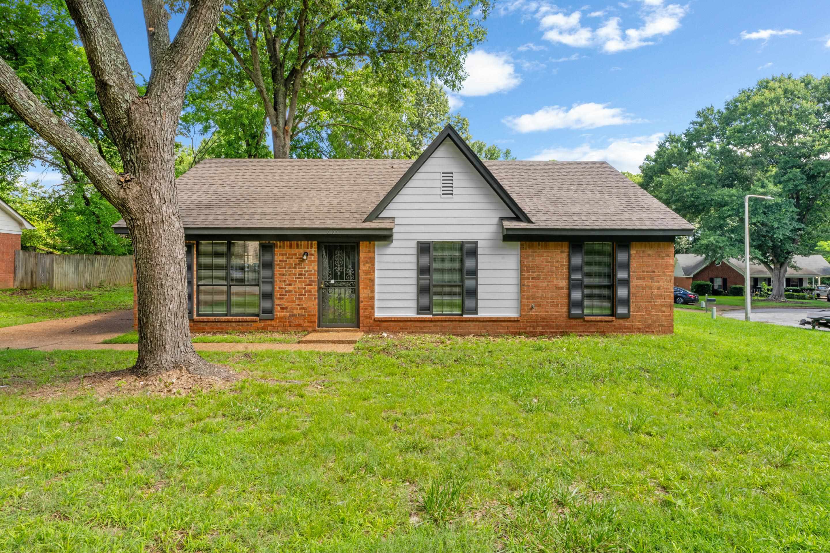 Classic brick façade complemented by fresh exterior paint, wrought iron security door, and a well-maintained setting in an established neighborhood.