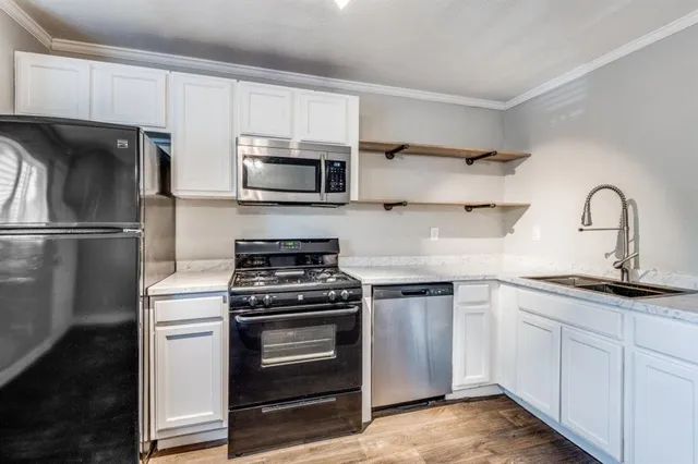 a kitchen with stainless steel appliances granite countertop a stove a sink and a refrigerator