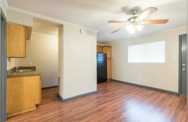 a view of a room with wooden floor a ceiling fan and closet area