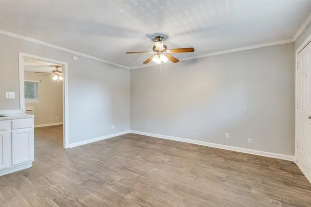 a view of a room with wooden floor and a ceiling fan