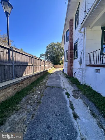 a view of a house with backyard and wooden fence