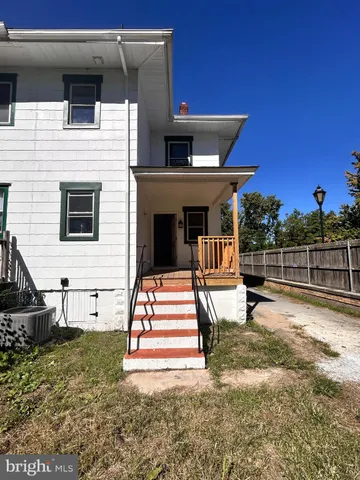 a view of house with backyard and tub