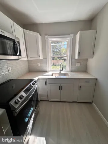 a kitchen with stainless steel appliances a sink stove and microwave