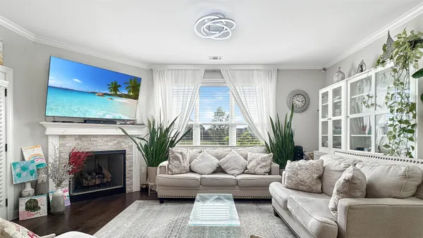 a living room with furniture a large window and a fireplace