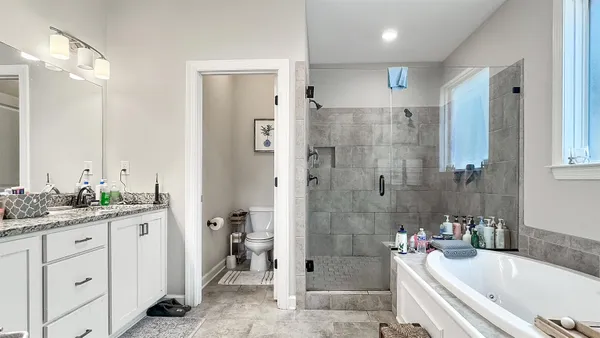 a bathroom with a tub sink toilet and shower