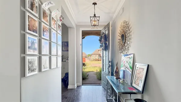 a view of a hallway with wooden floor and stairs