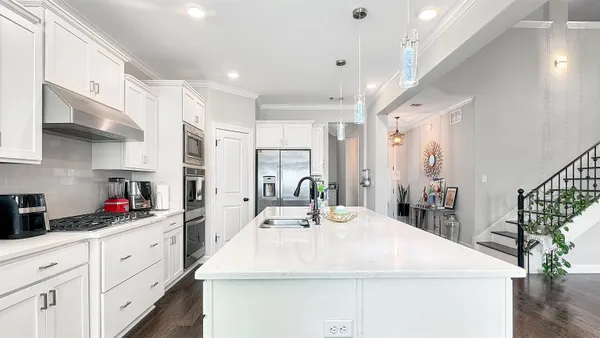 a large white kitchen with stainless steel appliances and white cabinets