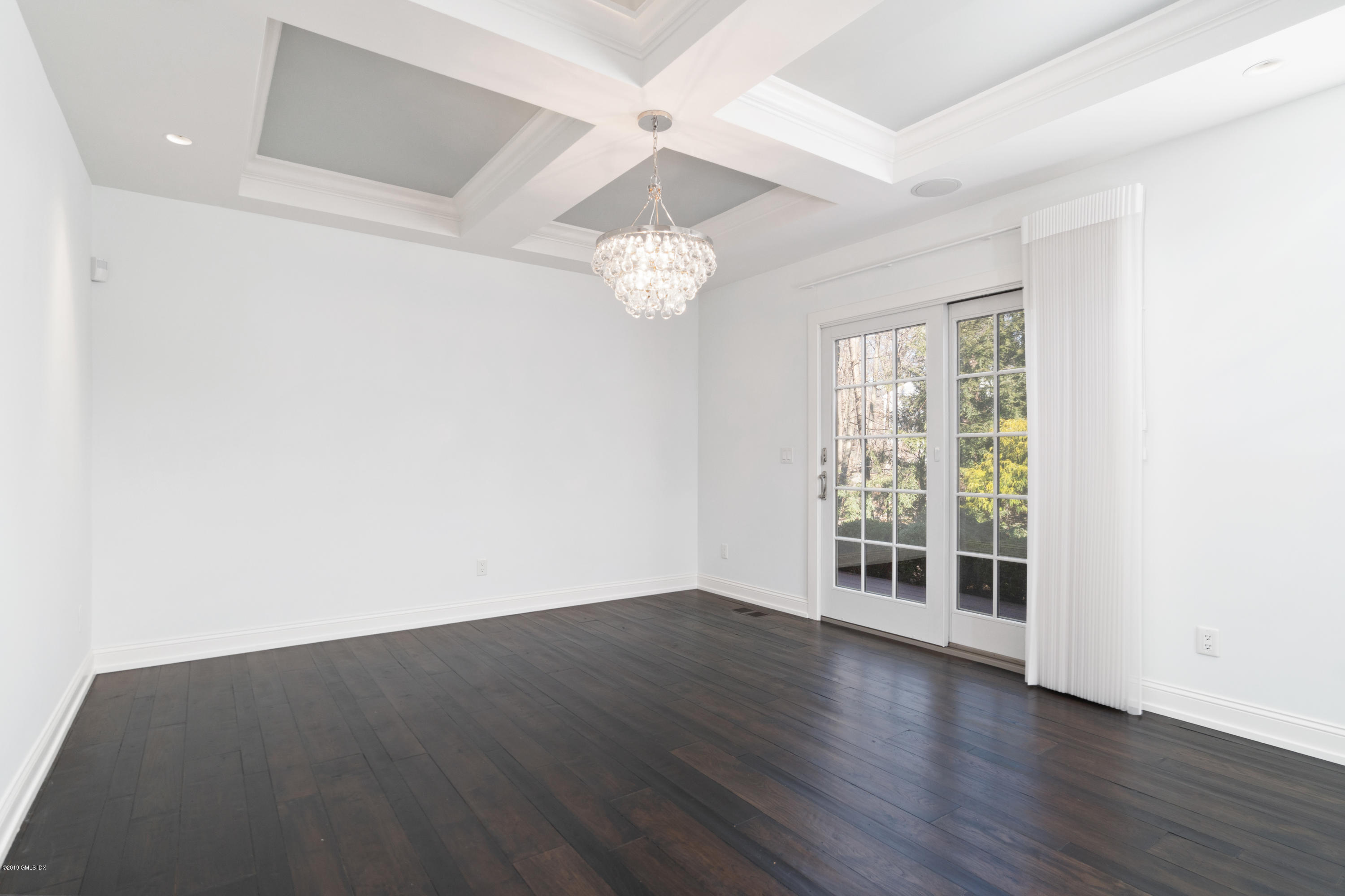 340 Valley Road, Unit 5 Cos Cob, CT 06807 - Photo 25 of 29 an empty room with wooden floor chandelier fan and windows