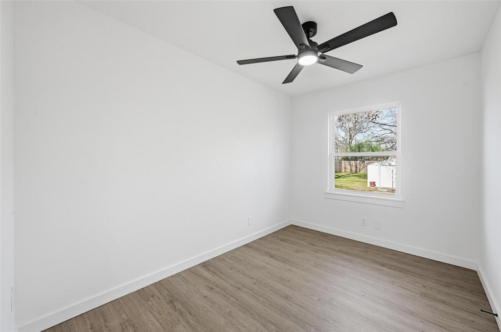 413 Wanda Way Hurst, TX 76053 - Photo 11 of 26 an empty room with a window and a ceiling fan