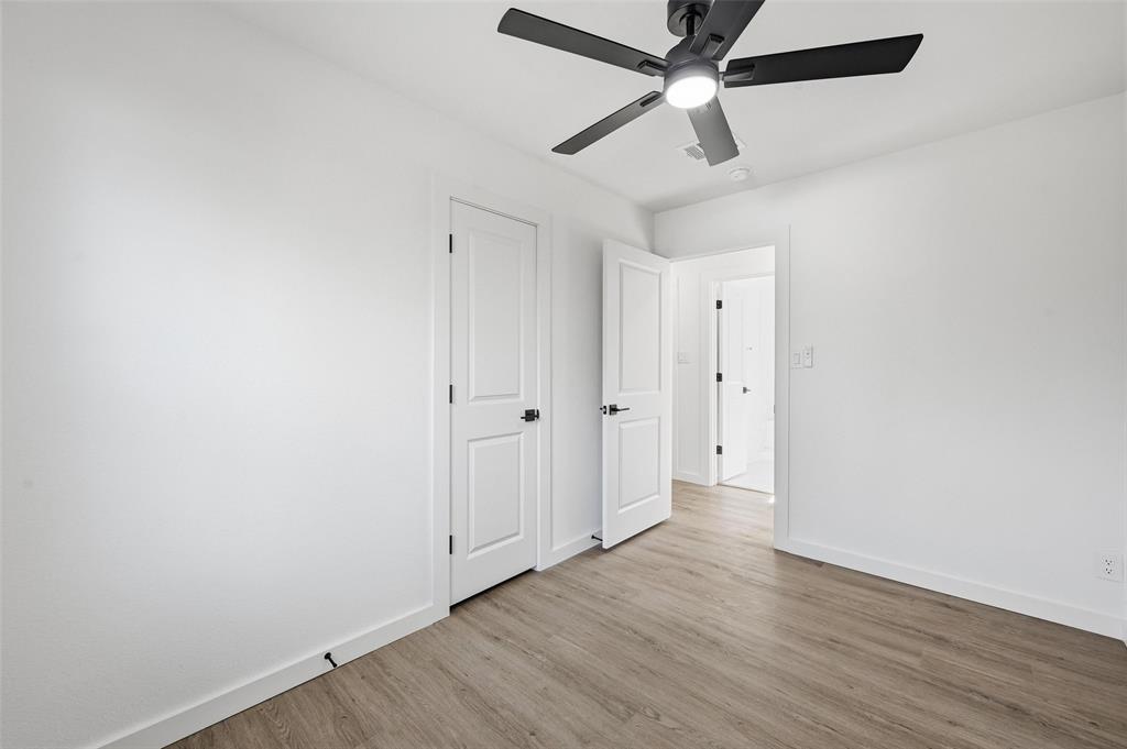 413 Wanda Way Hurst, TX 76053 - Photo 12 of 26 an empty room with wooden floor ceiling fan and window