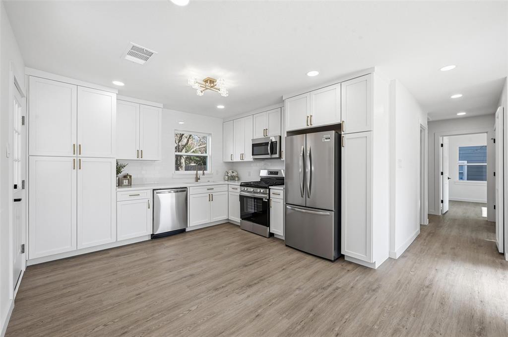 413 Wanda Way Hurst, TX 76053 - Photo 6 of 26 a kitchen with a refrigerator a sink and cabinets