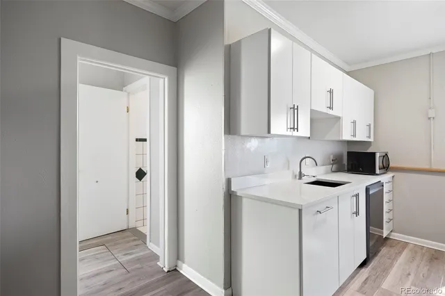 a view of a kitchen with white cabinets