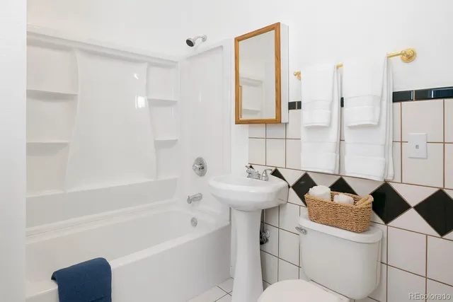 a bathroom with a granite countertop sink a toilet and bathtub