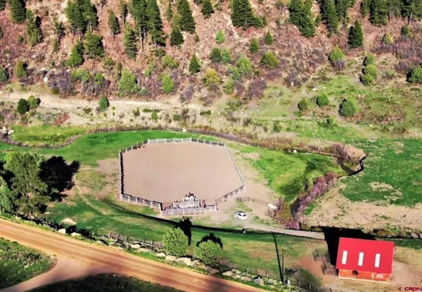 an aerial view of a house with a yard and lake view